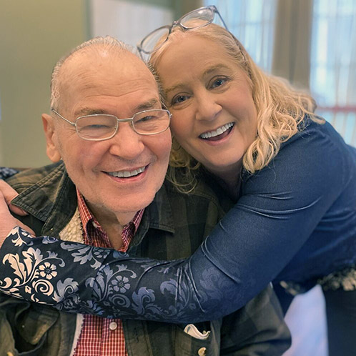 A man and woman embrace, sharing friendship at The Boulevard St. Charles.