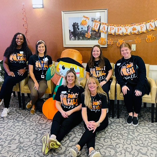 Team members at Boulevard St. Charles smile during a Halloween event.