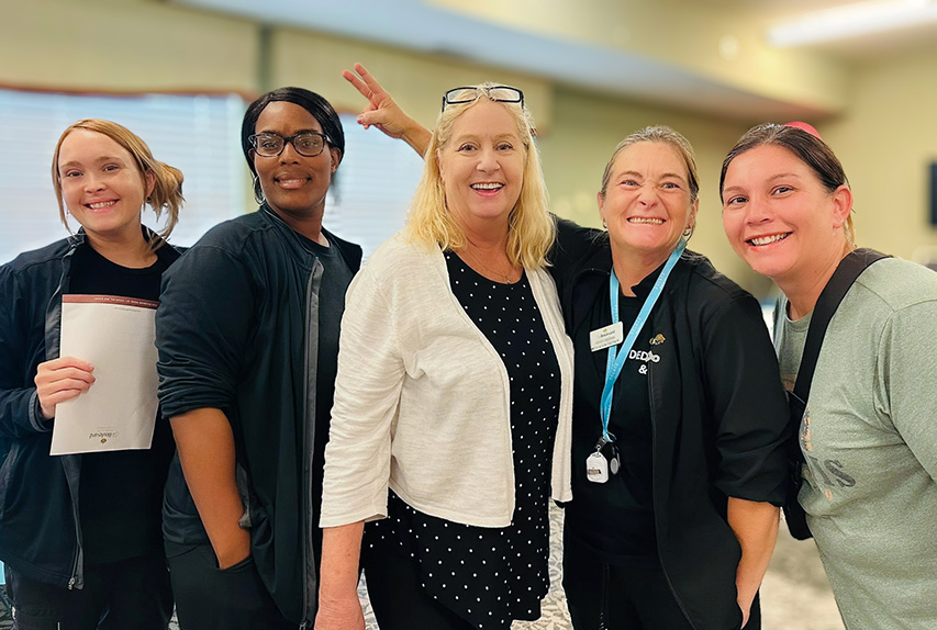 Several team members smile proudly during a relaxed moment at the community.