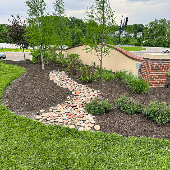 Freshly landscaped grounds at The Boulevard St. Charles, featuring plants, trees, and stones.